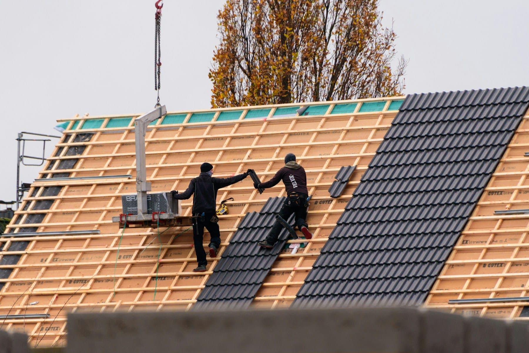 Roofers laying new slates on battens