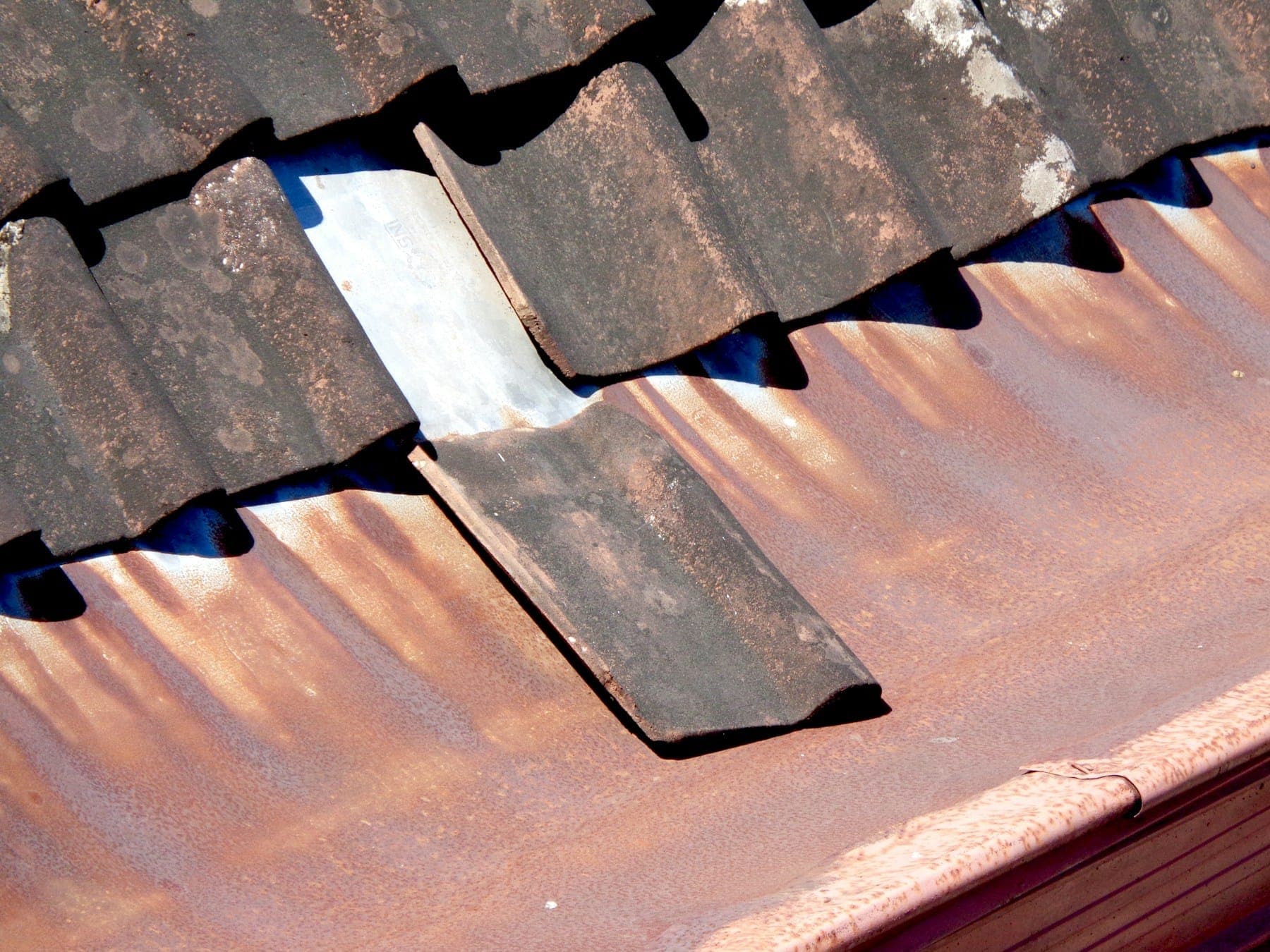 Slipped concrete roof tiles exposing the underlay, ready for repair