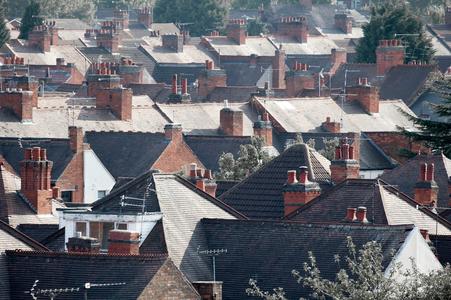 Rows of terraced house roofs with brick chimney stacks